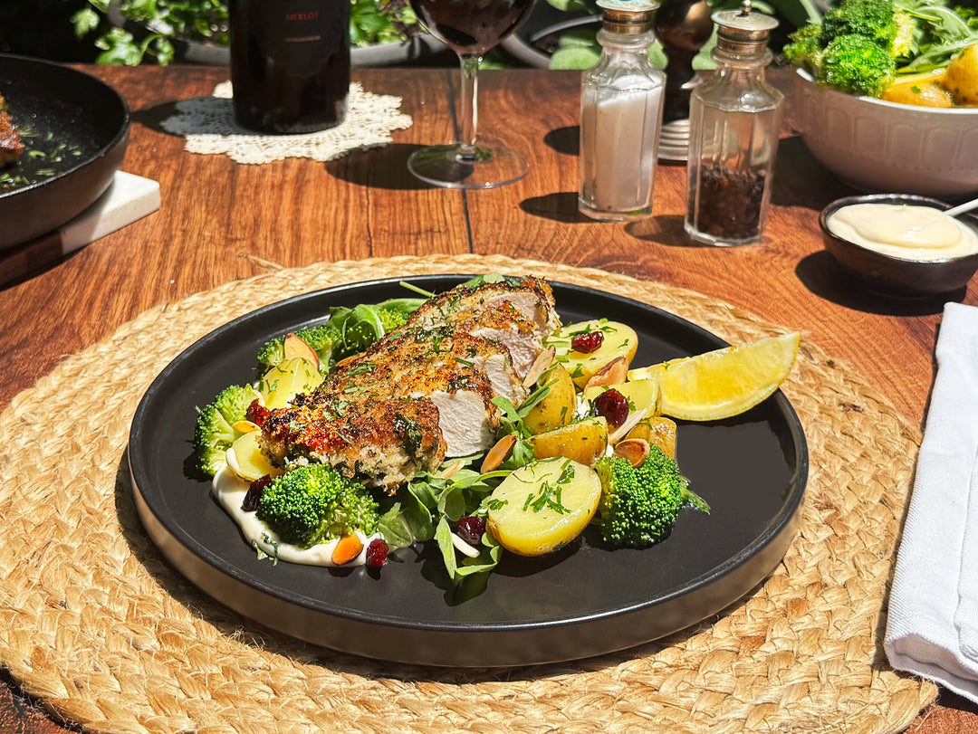 Plated dish of roasted meat with vegetables on a wooden table