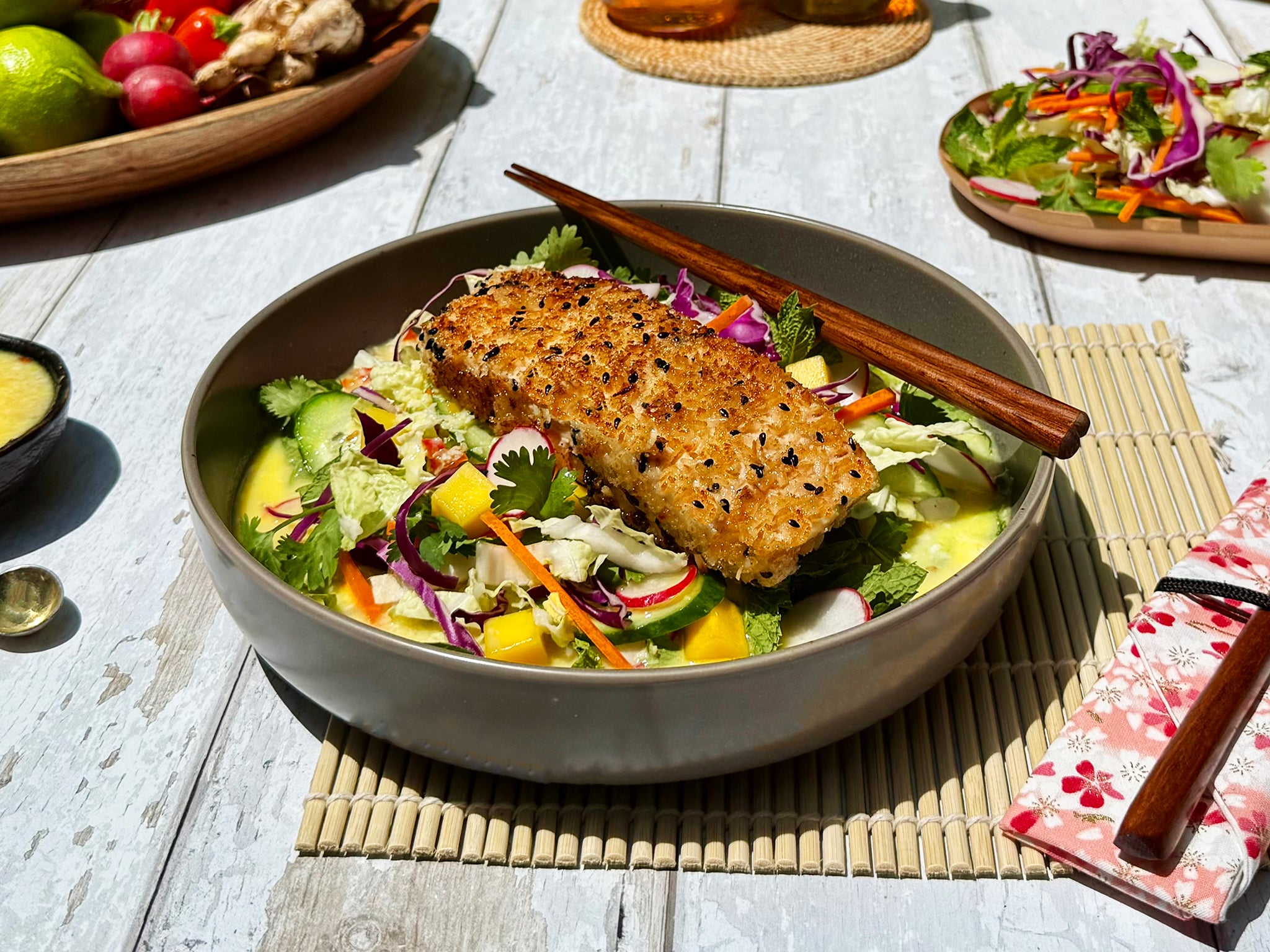 Bowl of salad with grilled fish on a wooden table