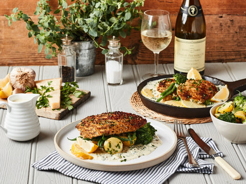 Dining table set with a meal, wine, and plants