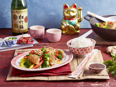 Chinese meal with rice, vegetables, and a bottle of Shaoxing wine on a wooden table.