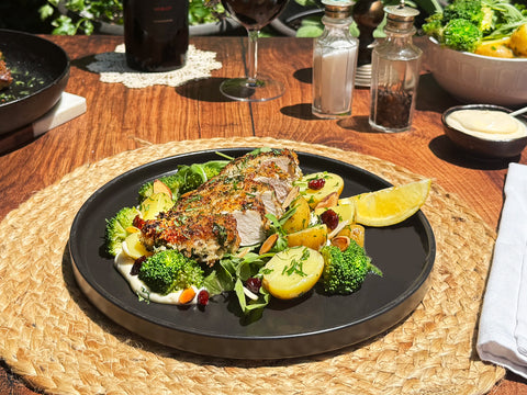 Plated dish of roasted meat with vegetables on a wooden table