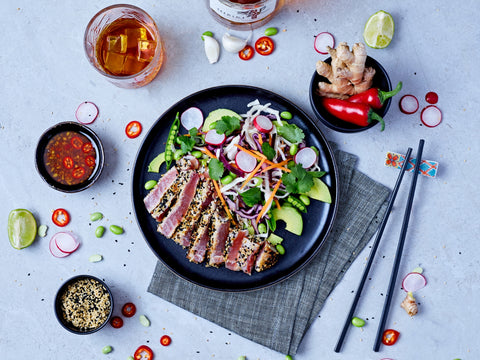 Plated dish of tuna salad with garnishes on a light gray background